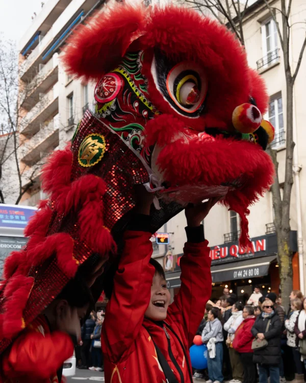 Alice · 01/03/2026 · 2534 x 3168 Cette photographie montre un lion dansant traditionnel chinois, sujet principal. La composition met en valeur le lion coloré et ses détails ornementaux, avec un danseur partiellement visible en dessous.Le cadrage est serré, centré sur le lion. La lumière semble naturelle, bien répartie, mettant en relief les couleurs vives. Les couleurs dominantes sont le rouge éclatant et le doré, typiques des costumes de lion.Le style est dynamique et culturel, évoquant une ambiance festive et traditionnelle, probablement lors d’une célébration comme le Nouvel An chinois.