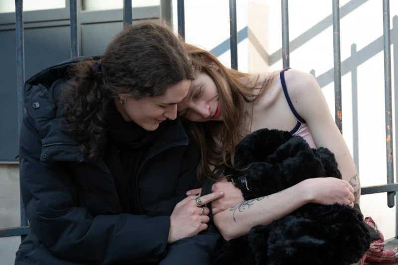 Jean-Marc · 21/03/2026 · 5159 x 3439 Cette photographie met en scène deux femmes comme sujets principaux, l’une caressant un chat noir. La composition est serrée, centrée sur l’interaction entre elles et l’animal. Le cadrage est rapproché, créant une ambiance intime.La lumière semble naturelle, douce et tamisée, probablement en intérieur ou près d’une source lumineuse diffuse. Les couleurs dominantes sont les tons froids (bleu du manteau, noir du chat) contrastant avec les teintes chaudes des cheveux et de la peau.Le style est réaliste et spontané, évoquant une scène du quotidien. L’ambiance est chaleureuse et apaisante.