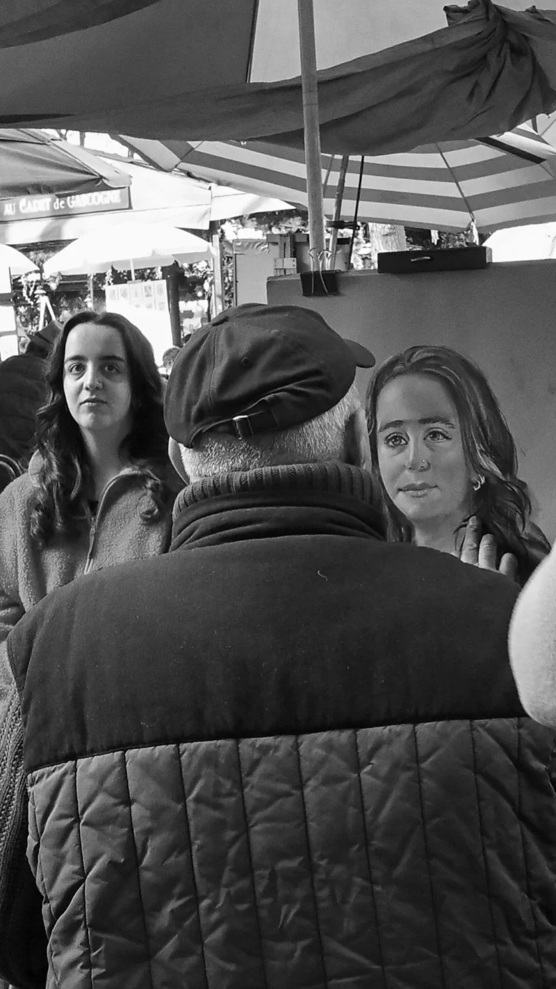 Aurélie · 01/01/2021 · 1080 x 1920 Cette photographie en noir et blanc montre trois personnes en conversation. Le sujet principal semble être les deux femmes en premier plan, dont une porte un béret et un manteau texturé. La composition est serrée, avec un cadrage rapproché mettant l'accent sur les visages et les expressions.La lumière est douce, sans ombres marquées, créant une ambiance naturelle et intime. L'absence de couleurs accentue les contrastes et les textures. Le style est documentaire et spontané, évoquant une scène du quotidien. L'ambiance est chaleureuse et conviviale.