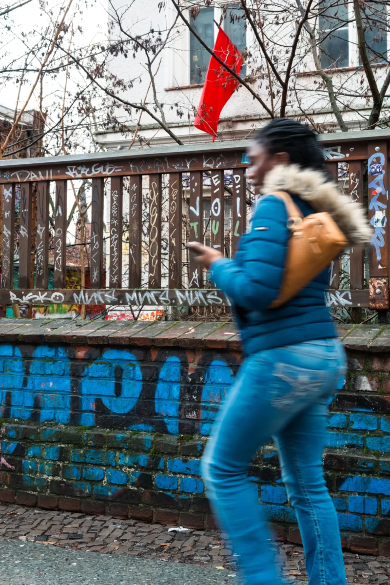 Daniel · 23/02/2026 · 3427 x 5141 Cette photographie met en scène une personne en mouvement, vue de dos, vêtue d’un bleu clair avec une veste à capuche et un jean. Le sujet principal semble danser ou faire un geste dynamique près d’un mur tagué.La composition est dynamique, avec un cadrage serré sur le sujet, laissant peu de place au fond. Les couleurs dominantes sont les bleus (vêtements, mur) et les teintes grises (arrière-plan urbain). La lumière semble naturelle, avec des contrastes modérés.L’ambiance est urbaine et énergique, renforcée par les graffitis et le mouvement du personnage. Le style est spontané et réaliste.