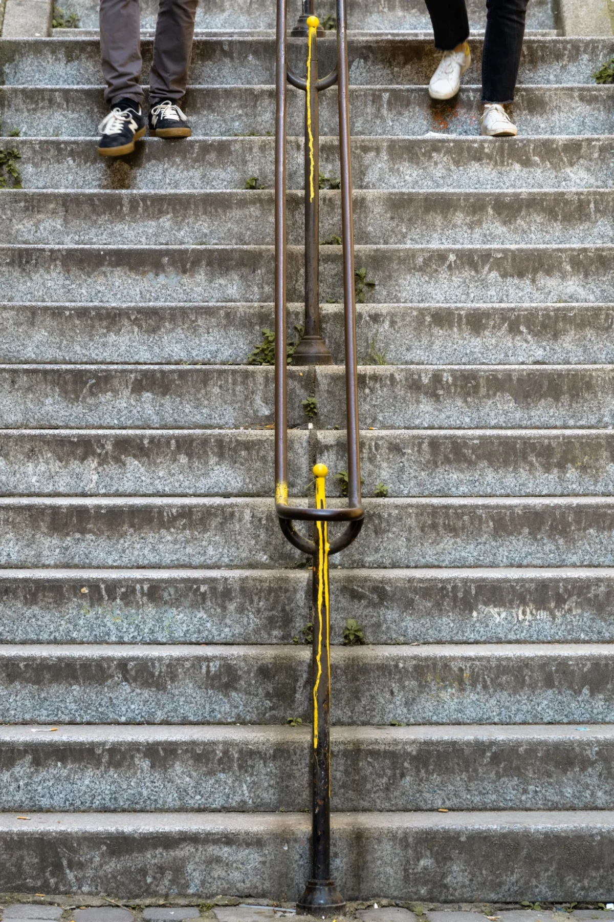 Daniel · 21/03/2026 · 3351 x 5026 Cette photographie met en scène un **rail de sécurité jaune** fixé à une **volée d'escaliers en pierre grise**. Le sujet principal est ce rail, légèrement incliné, avec une poignée en métal.La **composition** est simple et épurée, centrée sur le rail. Le **cadrage** est serré, excluant les distractions. La **lumière** naturelle semble douce, sans ombre marquée, créant une ambiance sobre.Les **couleurs dominantes** sont les tons gris des marches et le jaune vif du rail, contrastant avec le métal rouillé. Le style est **réaliste et documentaire**, évoquant une ambiance **urbaine et fonctionnelle**.