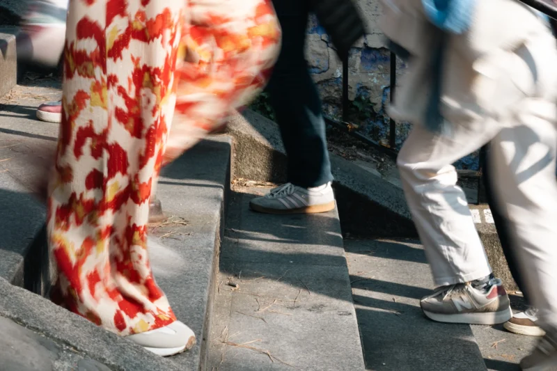 Daniel · 21/03/2026 · 6048 x 4032 Cette photographie capture des pieds et des bas en mouvement, avec des motifs rouges et blancs. Le sujet principal semble être les jambes en action, suggérant une marche rapide ou une danse.La composition est dynamique, avec un cadrage serré sur les bas et chaussures. La lumière est naturelle et semble provenir d’un angle latéral, créant des contrastes et des ombres douces. Les couleurs dominantes sont les rouges, blancs et noirs, apportant une touche vibrante et contrastée.Le style est spontané et artistique, évoquant un moment de vie quotidienne ou une performance. L’ambiance est énergique et légèrement floue, renforçant le sentiment de mouvement.