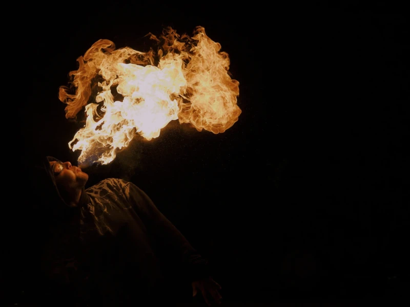 Les burners du Palais de Tokyo Cette photographie met en scène une **flamme géante** comme sujet principal, probablement issue d’un jet de gaz en combustion. La **composition** est épurée, centrée sur cette explosion lumineuse.Le **cadrage** est serré, isolant la flamme sur un fond noir, ce qui accentue son impact. La **lumière** est intense et contrastée, créant une ambiance dramatique. Les **couleurs dominantes** sont des **tons chauds** (jaunes, oranges) sur un arrière-plan sombre.Le style est **spectaculaire et cinématographique**, évoquant une scène de feu ou d’explosion. L’**ambiance** est à la fois **puissante et mystérieuse**, avec une touche de danger et de grandeur.