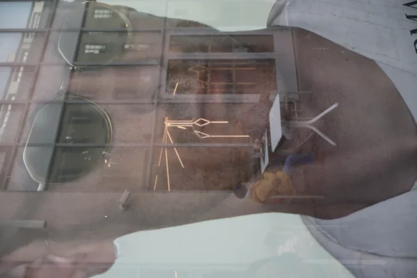 Camilla · 07/03/2026 · 6000 x 4000 Cette photographie montre une personne en train de manipuler un objet métallique à travers une vitre, probablement dans un contexte médical ou scientifique.Le sujet principal est les mains et les instruments tenus par la personne, reflétés et légèrement floutés. La composition est centrée sur cet élément, avec un cadrage serré. La lumière est diffuse et tamisée, créant une ambiance clinique et stérile. Les couleurs dominantes sont des teintes froides : gris, blanc et quelques reflets métalliques. Le style est documentaire et technique, évoquant une ambiance aseptisée et professionnelle.