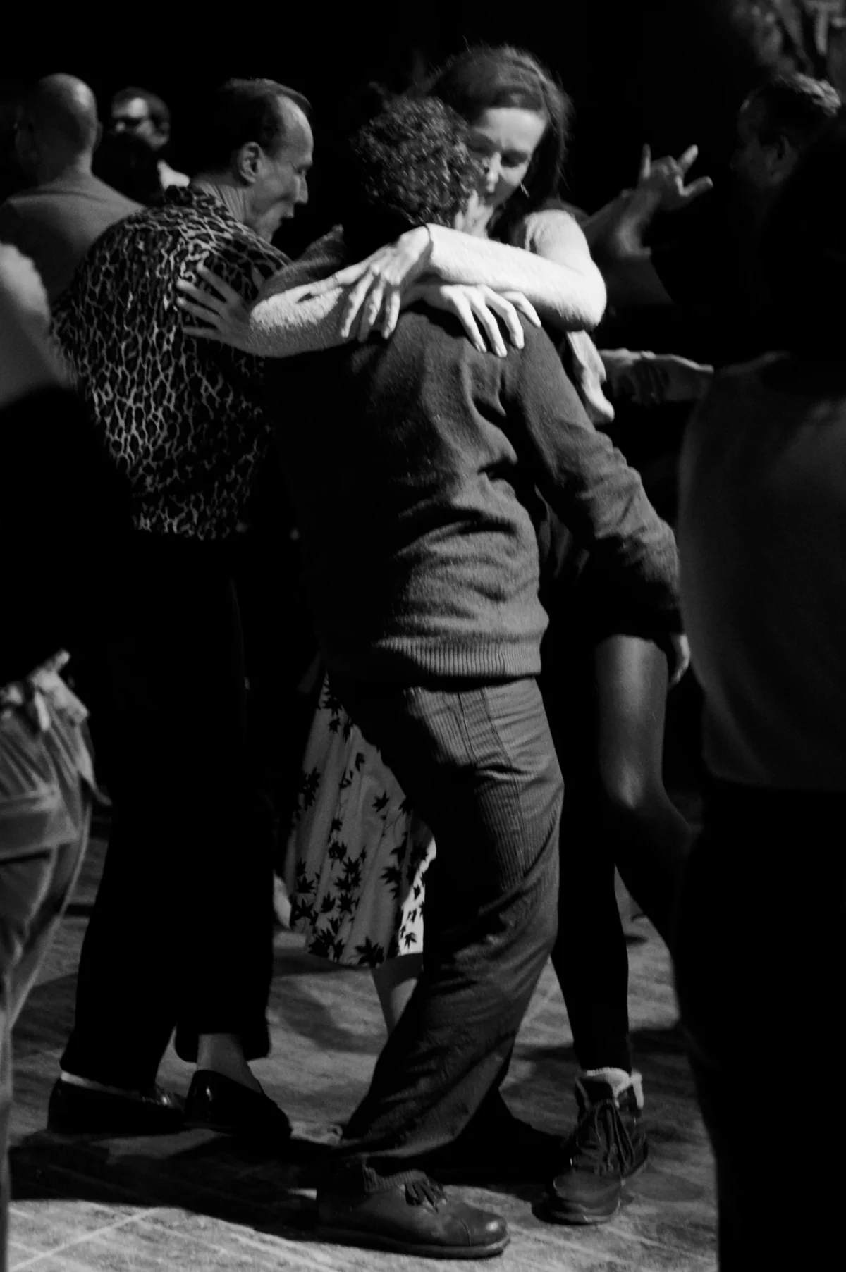 Thomas · 09/11/2025 · 2724 x 4096 Cette photographie en noir et blanc capture un couple en train de danser, probablement une danse latine ou sensuelle. Le sujet principal est le couple au centre, avec une composition dynamique et serrée.Le cadrage est serré, mettant l'accent sur l'interaction entre les deux danseurs. La lumière est tamisée, créant une ambiance intimiste et dramatique. Les couleurs dominantes, bien que réduites au noir et blanc, suggèrent des tons sombres et contrastés.Le style est spontané et authentique, évoquant une ambiance chaleureuse et passionnée, typique d'un club ou d'une soirée dansante.