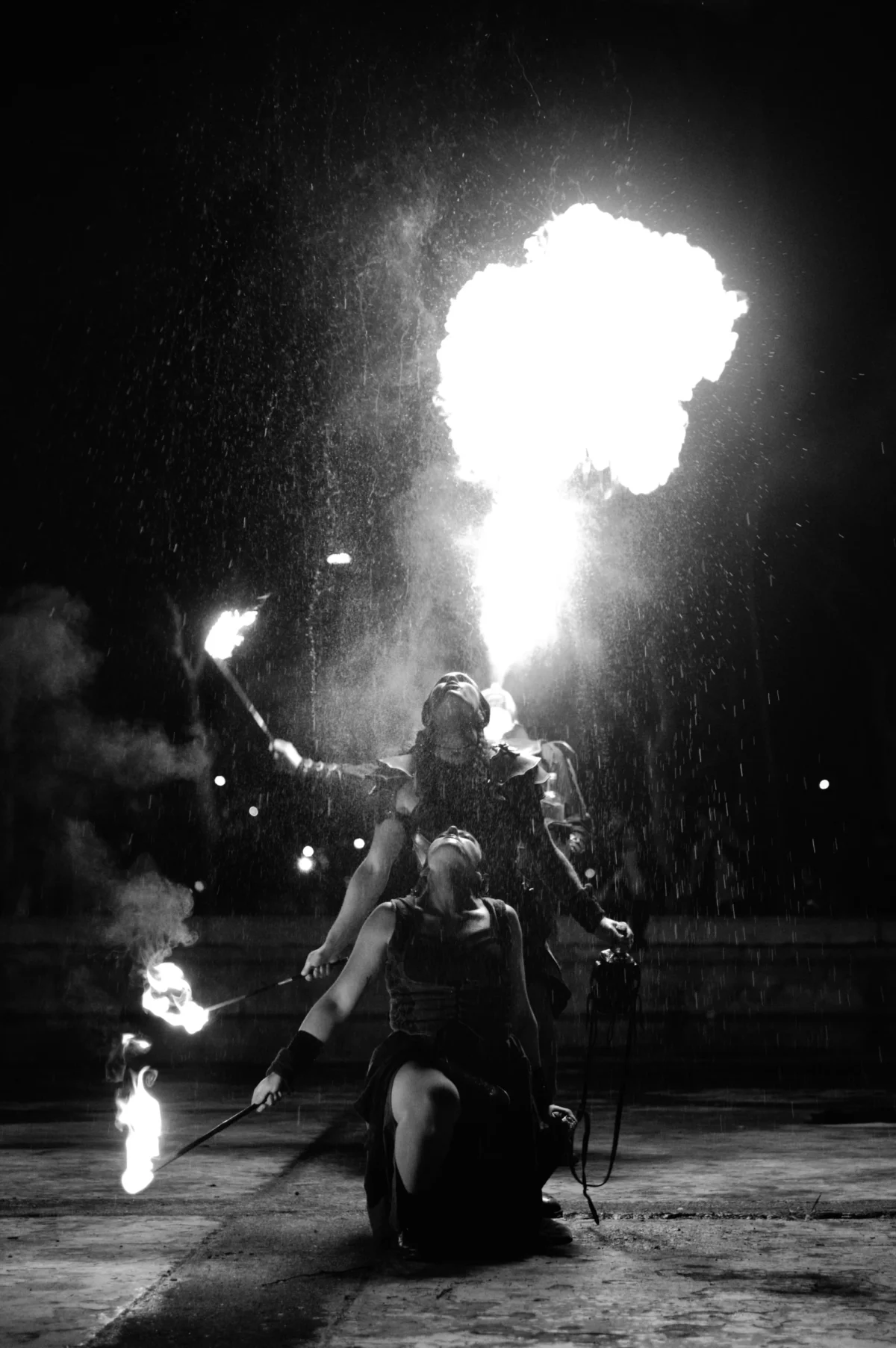 Thomas · 24/01/2026 · 2724 x 4096 Cette photographie en noir et blanc capture un spectacle de feu. Le sujet principal est un artiste manipulant des jets de flammes autour de lui. La composition est dynamique, centrée sur l’artiste en action, avec des éclats de feu qui s’élèvent et s’étendent dans l’espace.Le cadrage est serré, mettant en valeur l’intensité du moment. La lumière est dramatique, avec des contrastes forts entre les zones sombres et les éclairs lumineux des flammes. L’ambiance est spectaculaire et intense, évoquant puissance et maîtrise. Le style est artistique et théâtral, renforcé par le monochrome.