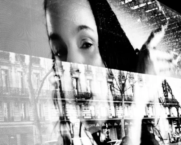 Laurence Givry · 07/03/2026 · 1125 x 900 Cette photographie présente un visage flou en premier plan, partiellement visible, superposé à une image plus nette en arrière-plan. Le sujet principal semble être une scène urbaine ou industrielle en noir et blanc, avec des éléments architecturaux et des structures métalliques.La composition joue sur les contrastes entre flou et netteté, créant un effet de profondeur. Le cadrage est serré sur le visage, mais l'arrière-plan domine visuellement. La lumière est contrastée, avec des ombres marquées. Les couleurs dominantes sont les nuances de gris, renforçant l'ambiance monochrome. Le style évoque une esthétique moderne et expérimentale, mêlant abstraction et réalisme, pour une ambiance à la fois mystérieuse et dynamique.