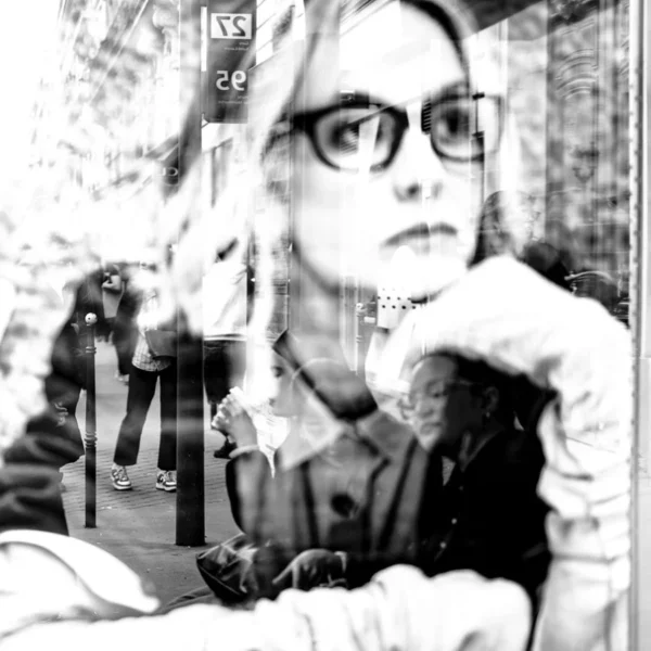Laurence Givry · 07/03/2026 · 900 x 900 Cette photographie en noir et blanc met en scène une personne comme sujet principal, vêtue d’un pull et portant des lunettes, en train de fumer. La composition est dynamique, avec un cadrage serré et légèrement flou, créant un effet de profondeur.L’ambiance est intime et mystérieuse, renforcée par les reflets et les ombres. La lumière semble naturelle mais tamisée, ajoutant une touche mélancolique. Le style rappelle les clichés vintage ou artistiques, avec des distorsions et des superpositions. Les tons dominants sont les gris et noirs, accentuant le côté dramatique et poétique.