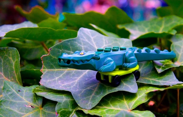 Pascale CHESNOT · 14/03/2026 · 1000 x 639 Cette photographie met en scène un **lézard bleu** (ou gecko) comme sujet principal, posé sur des feuilles vertes. La **composition** est simple et naturelle, avec un cadrage serré sur l’animal et son environnement immédiat. La **lumière**, douce et légèrement tamisée, crée des ombres subtiles, mettant en valeur les textures des feuilles et les écailles du lézard. Les **couleurs dominantes** sont le **bleu électrique** du reptile et le **vert profond** des feuilles, formant un contraste saisissant. Le style est **réaliste et naturaliste**, évoquant une ambiance **calme et mystérieuse**, presque onirique.