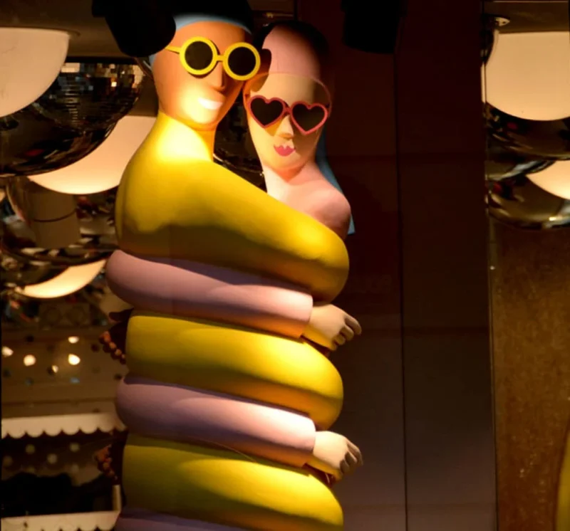 Pascale · 27/10/2018 · 1000 x 933 Cette photographie montre deux personnages stylisés, dont l’un semble être une créature jaune et violette en forme de banane, portant une humaine aux lunettes noires. Le sujet principal est leur étreinte.La composition est serrée, avec un cadrage rapproché. Les couleurs dominantes sont le jaune vif, le violet et le noir. La lumière est tamisée, créant une ambiance mystérieuse et légèrement dramatique. Le style évoque un univers fantastique ou animé, avec des traits exagérés et expressifs. L’ambiance est à la fois ludique et légèrement onirique.