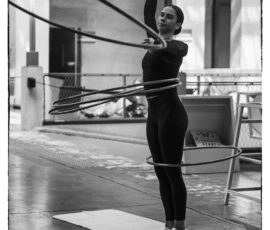 Thierry · 22/04/2026 · 2560 x 3840 Cette photographie en noir et blanc met en scène une danseuse ou gymnaste utilisant des cerceaux suspendus. Le sujet principal est centré, en position dynamique, avec une posture élancée et gracieuse. La composition est épurée, avec un cadrage serré qui isole le sujet sur un fond neutre et légèrement flou.La lumière, naturelle et douce, accentue les contours et crée des ombres marquées. L’ambiance est à la fois sportive et artistique, évoquant concentration et fluidité. Le style est sobre et intemporel, renforcé par le monochrome.