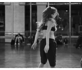 Thierry · 22/04/2026 · 3840 x 2560 Cette photographie en noir et blanc met en scène une jeune femme comme sujet principal, en mouvement dans une salle de danse. Elle porte une tenue sportive et semble exécuter un pas de danse.La composition est dynamique, avec un cadrage serré sur elle, mais laissant apercevoir d'autres danseurs en arrière-plan. La lumière est douce et naturelle, éclairant la scène sans créer d'ombres marquées. L'ambiance est à la fois intense et élégante, évoquant la concentration et la grâce du ballet ou de la danse contemporaine. Le style est épuré et artistique.