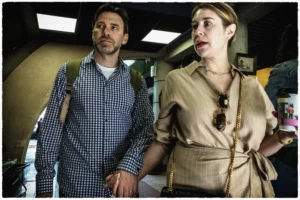 Thierry · 25/04/2026 · 3840 x 2560 Cette photographie montre deux acteurs en costume, probablement issus d’un film de science-fiction. Le sujet principal semble être leur interaction, avec un homme en chemise à carreaux et une femme en tenue de voyageur des années 1940.La composition est serrée, centrée sur eux, avec un cadrage en plan moyen. La lumière est douce et uniforme, éclairant leurs visages sans ombres marquées. Les couleurs dominantes sont des tons neutres (beige, bleu, gris), avec des détails plus vifs sur leurs vêtements.Le style évoque un mélange rétro-futuriste, créant une ambiance à la fois réaliste et onirique, typique des récits spatiaux ou temporels.