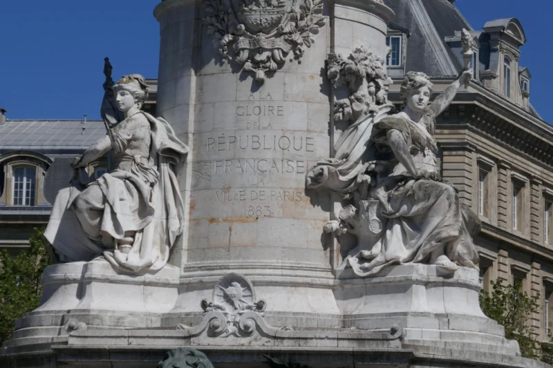 Bao · 23/04/2026 · 5472 x 3648 Cette photographie montre une partie d'un monument sculpté dédié à la République française. Le sujet principal est une statue allégorique représentant des figures féminines symbolisant des valeurs républicaines.La composition met en avant des détails sculpturaux complexes, avec un cadrage serré sur les bas-reliefs et les visages. La lumière naturelle éclaire les sculptures, mettant en valeur leurs textures et ombres. Les couleurs dominantes sont les tons gris-beige des pierres, avec des touches de bleu et de vert en arrière-plan.Le style est classique et monumental, évoquant une ambiance solennelle et historique.