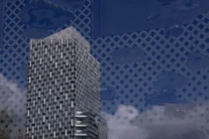 Laurence · 28/03/2026 · 1350 x 900 Cette photographie met en scène un immeuble moderne au design géométrique, avec une façade en damier. Le sujet principal est ce bâtiment, reflété partiellement dans une surface vitrée ou métallique texturée.La composition oppose l’architecture verticale à un ciel nuageux. Le cadrage est serré, centré sur l’édifice. La lumière semble naturelle mais diffuse, adoucissant les contrastes. Les couleurs dominantes sont les gris et les bleus, renforcés par les tons métalliques du reflet.Le style est épuré et contemporain, évoquant une ambiance urbaine et futuriste, presque abstraite.