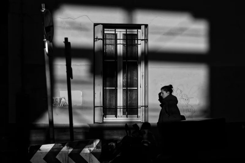 Mickaël · 07/02/2026 · 4604 x 3074 Cette photographie en noir et blanc met en scène une personne assise près d’une fenêtre, silhouette sombre face à la lumière. Le sujet principal est cette silhouette, partiellement éclairée, avec un chien à ses pieds.La composition joue sur les contrastes lumineux et les ombres, créant une ambiance contemplative. Le cadrage serré et la lumière filtrée à travers les vitres renforcent une atmosphère mélancolique et introspective. Les couleurs dominantes sont les tons de gris, accentuant le côté dramatique et poétique. Le style rappelle le réalisme photographique avec une touche artistique et intime.