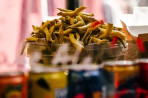 Don · 25/04/2026 · 1676 x 1117 Cette photographie met en scène un **bol de frites** comme sujet principal, généreusement garnies de sauce et de morceaux de viande ou de légumes.La **composition** est simple et centrée, avec un **cadrage serré** qui isole le bol. L’arrière-plan flou suggère un environnement informel, probablement un restaurant ou une cantine.La **lumière** est douce et naturelle, créant des contrastes subtils. Les **couleurs dominantes** sont les tons chauds (beige des frites, rouge de la sauce) et des teintes vives (jaune, vert).Le style est **photojournalistique**, réaliste et appétissant, évoquant une **ambiance conviviale et décontractée**.