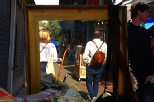 Bao · 5472 x 3648 Cette photographie montre deux personnes reflétées dans une vitrine brisée. Le sujet principal est la scène de rue avec des éléments de désordre, comme des débris et des objets éparpillés.La composition utilise un cadrage serré sur la vitrine, créant un effet de miroir. La lumière est naturelle, probablement en journée, avec des ombres marquées. Les couleurs dominantes sont des tons neutres (gris, beige) et quelques touches vives (vêtements colorés).Le style est documentaire et spontané, évoquant une ambiance de désordre et de chaos urbain, peut-être après un événement perturbateur.