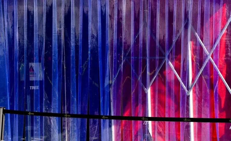 Franck T. · 24/04/2026 · 1400 x 857 Cette photographie met en scène un **mur métallique ondulé** reflétant une structure lumineuse colorée. Le **sujet principal** semble être la **superposition des reflets** et des jeux de lumière.La **composition** joue sur les **lignes verticales** et les **courbes**, renforçant une impression de mouvement. Le **cadrage serré** isole ces éléments, créant une ambiance presque abstraite. Les **couleurs dominantes** sont des **bleus profonds, violets et rouges**, dynamisées par des éclairages artificiels.Le **style** est **moderne et urbain**, évoquant une ambiance **futuriste et industrielle**. L’**ambiance** est à la fois **énergique et mystérieuse**, grâce aux contrastes lumineux et aux reflets déformés.