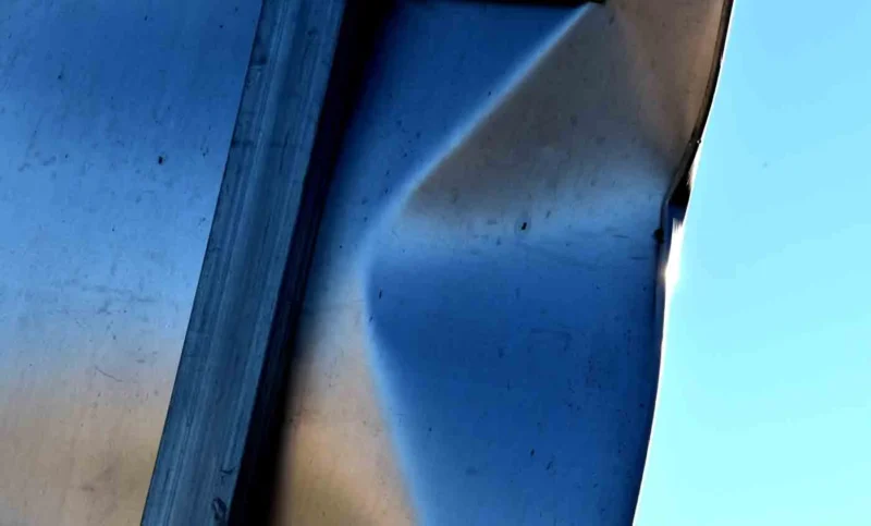 Franck T. · 09/04/2026 · 1400 x 846 Cette photographie montre principalement un angle d’un objet métallique, probablement une partie de structure ou de véhicule, avec une surface réfléchissante et légèrement endommagée.La composition est simple et géométrique, centrée sur les lignes droites et les reflets. Le cadrage est serré, mettant en valeur les détails de la surface et le ciel bleu en arrière-plan. La lumière naturelle est douce, créant des contrastes entre ombres et reflets.Les couleurs dominantes sont le bleu du ciel et les teintes métalliques grises et bleutées. Le style est minimaliste et documentaire, évoquant une ambiance industrielle et sobre.
