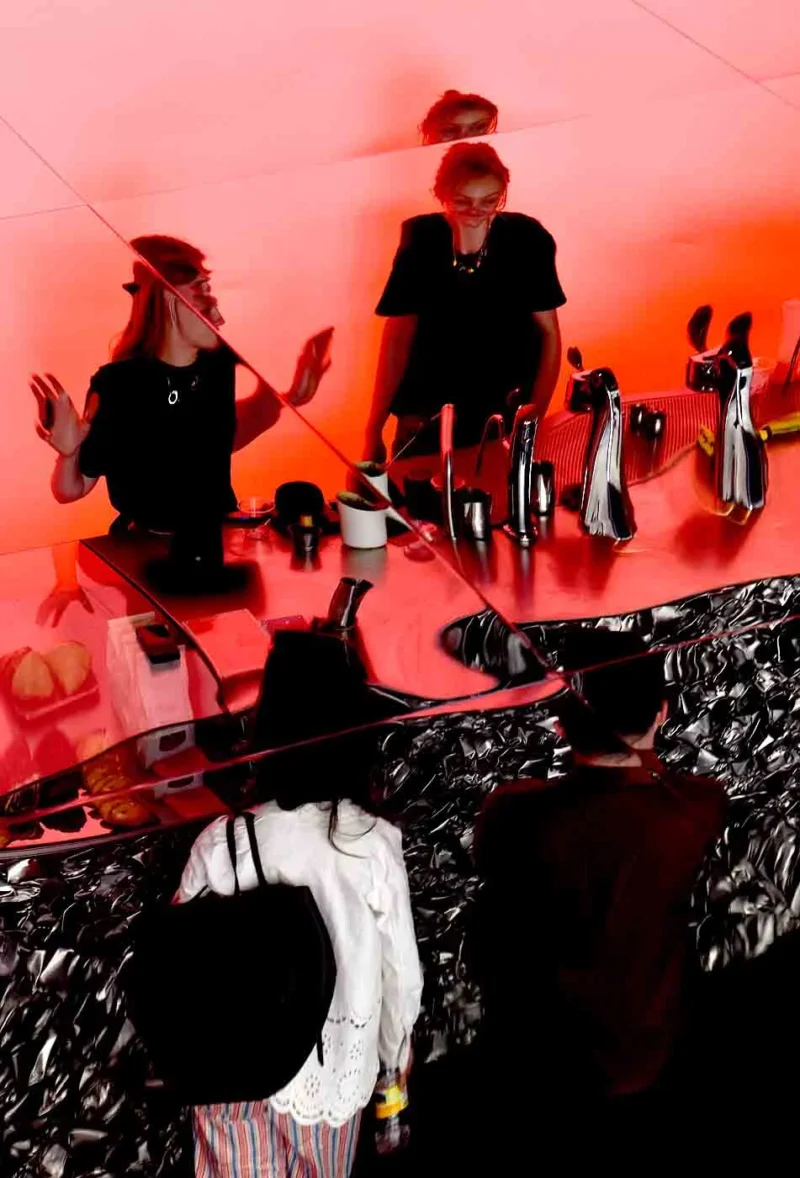 Franck T. · 25/04/2026 · 951 x 1400 Cette photographie capture une scène de concert ou de spectacle. Le sujet principal semble être un groupe de musiciens, dont certains jouent d’instruments à vent ou à percussion.La composition montre des silhouettes floues en arrière-plan, créant une ambiance dynamique. Le cadrage est serré sur les musiciens en premier plan, avec une profondeur de champ réduite. La lumière est tamisée et rougeâtre, ajoutant une atmosphère dramatique et intense. Les couleurs dominantes sont le rouge profond et des teintes sombres, renforçant l’émotion.Le style évoque un concert intimiste ou une performance artistique, avec une ambiance à la fois énergique et mystérieuse.
