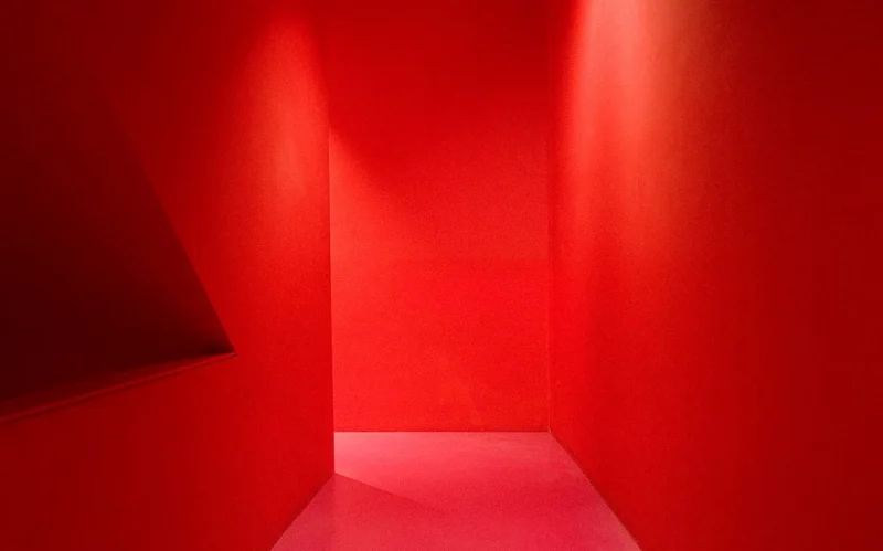Franck T. · 12/11/2025 · 1128 x 703 Cette photographie présente une scène minimaliste et abstraite. Le **sujet principal** est une lumière rouge intense éclairant un espace vide, créant des contrastes nets. La **composition** repose sur des lignes géométriques simples : un angle droit et une ombre noire sur la gauche.Le **cadrage** est serré, mettant en valeur les jeux de lumière et d’ombre. Les **couleurs dominantes** sont le rouge vif et le noir, avec des dégradés vers le blanc et le gris.Le **style** est épuré et artistique, évoquant une ambiance **surréaliste ou cinématographique**, presque dramatique. L’**atmosphère** est mystérieuse et immersive, jouant sur les contrastes lumineux.