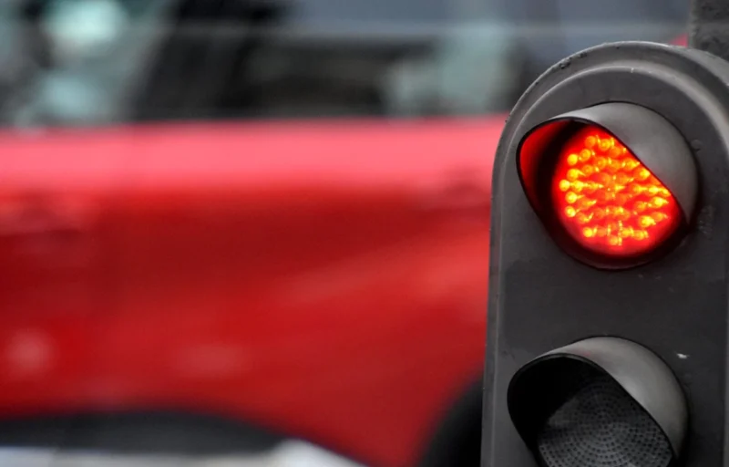 Franck T. · 26/01/2026 · 1400 x 896 Cette photographie met en scène un **feu de signalisation rouge** comme sujet principal, avec ses diodes lumineuses allumées. En arrière-plan flou, une partie de voiture rouge est visible, créant un **cadrage serré** et une profondeur limitée.La **composition** est simple et centrée sur l'élément lumineux. La **lumière** est vive et contrastée, accentuant l’éclat des diodes. Les **couleurs dominantes** sont le rouge vif du feu et de la voiture, avec des teintes sombres en arrière-plan.Le style est **réaliste et direct**, évoquant une ambiance urbaine et moderne, presque minimaliste.