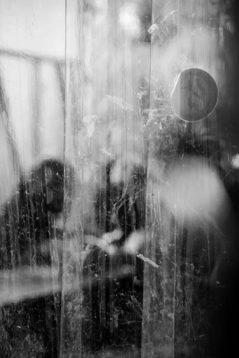 Pascale · 01/05/2026 · 1000 x 1500 Cette photographie en noir et blanc met en scène une scène floue et onirique. Le sujet principal semble être une silhouette indistincte à travers une pluie ou un rideau d’eau, évoquant une atmosphère mystérieuse. La composition joue sur les contrastes entre flou et netteté, avec un cadrage serré sur les gouttes d’eau en premier plan.La lumière est douce et diffuse, créant des effets de flou artistique. Les couleurs dominantes, bien que monochromes, exploitent les nuances de gris pour renforcer l’ambiance mélancolique et poétique. Le style rappelle le flou artistique ou le flou de mouvement, renforçant une ambiance contemplative et presque rêveuse.