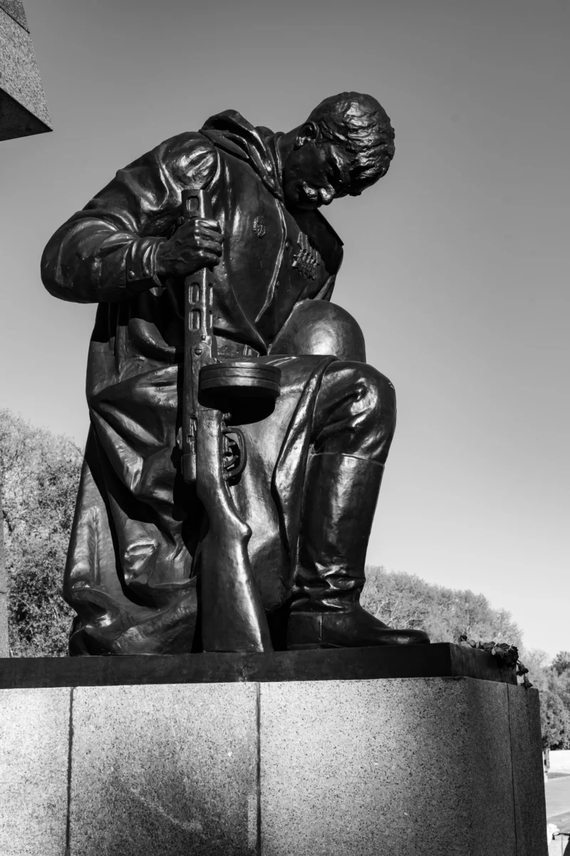 Claude · 3662 x 5493 Cette photographie montre une statue en noir et blanc représentant un soldat assis, le buste penché, tenant un fusil. Le sujet principal est ce soldat, évoquant la fatigue ou la réflexion.La composition est simple et centrée, avec un cadrage serré sur la statue, qui repose sur un socle. La lumière, naturelle, met en valeur les contours et les détails de la sculpture. Les couleurs dominantes sont les nuances de gris, typiques d'une photo en noir et blanc.Le style est réaliste et sobre, créant une ambiance à la fois solennelle et mélancolique.