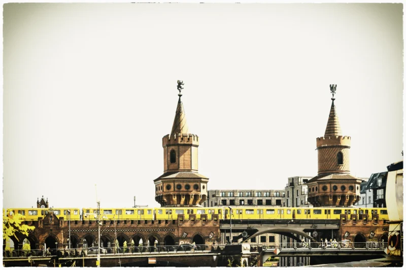 Thierry · 02/05/2026 · 3840 x 2560 Cette photographie met en scène le **viaduc de la gare de Munich** avec ses deux tours emblématiques. Le **sujet principal** est ce pont ferroviaire, souligné par une composition symétrique et horizontale.Le **cadrage** est large, capturant le viaduc et ses alentours. La **lumière** est douce, légèrement voilée, créant une ambiance nostalgique. Les **couleurs dominantes** sont des tons chauds et sépia, avec des touches de jaune et de brun.Le **style** est vintage, évoquant une époque ancienne. L’**ambiance** est à la fois industrielle et poétique, mêlant architecture imposante et sérénité.