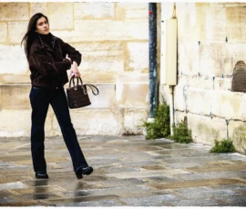 Thierry · 15/05/2026 · 3840 x 2560 Cette photographie met en scène une femme comme sujet principal, vêtue d’un manteau noir et de bottes, tenant un sac à main. La composition est simple et épurée, avec un cadrage serré sur elle en mouvement.L’ambiance est urbaine et légèrement mélancolique. La lumière, naturelle mais tamisée, semble douce et diffuse, créant des contrastes subtils. Les couleurs dominantes sont les tons froids (gris, noir) et quelques touches de beige sur le mur en pierre.Le style est sobre et réaliste, évoquant une atmosphère contemporaine et introspective.