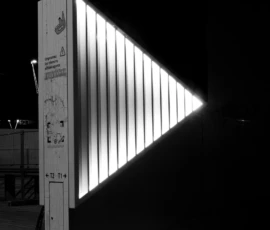 Claude · 3927 x 5891 Cette photographie montre un panneau lumineux triangulaire éclairé de nuit, indiquant « entrée BnF ». Le sujet principal est ce triangle lumineux, encadré par une structure verticale blanche portant des logos et inscriptions.La composition est épurée, avec un cadrage serré sur le panneau. La lumière est douce et contrastée, mettant en valeur le triangle lumineux. Les couleurs dominantes sont le blanc, le noir et une touche de bleu froid. Le style est minimaliste et moderne, créant une ambiance nocturne et urbaine, à la fois sobre et dynamique.