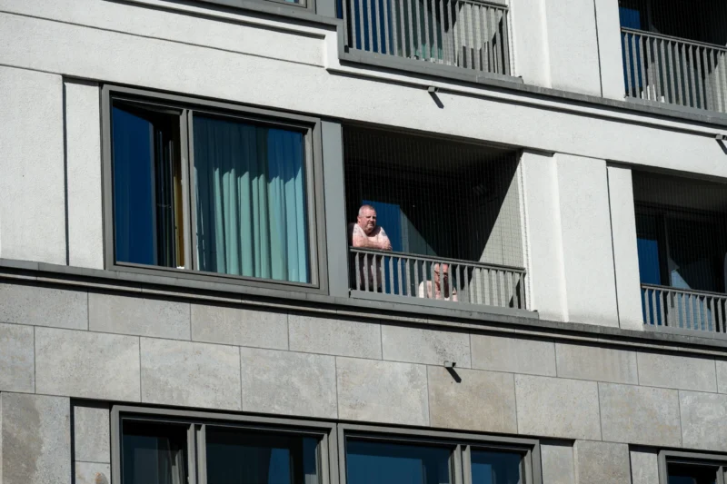 Jean-Marc · 01/05/2026 · 5616 x 3744 Cette photographie montre une personne assise sur un balcon, sujet principal. La composition met en valeur le contraste entre l’architecture moderne et la présence humaine. Le cadrage est serré, centré sur le balcon et la façade en pierre grise.La lumière est naturelle, probablement en journée, avec des ombres douces. Les couleurs dominantes sont les tons gris-beige de la pierre et les teintes bleutées des fenêtres. Le style est réaliste et documentaire, capturant un moment de calme. L’ambiance est à la fois urbaine et intime, évoquant la solitude dans un cadre architectural contemporain.
