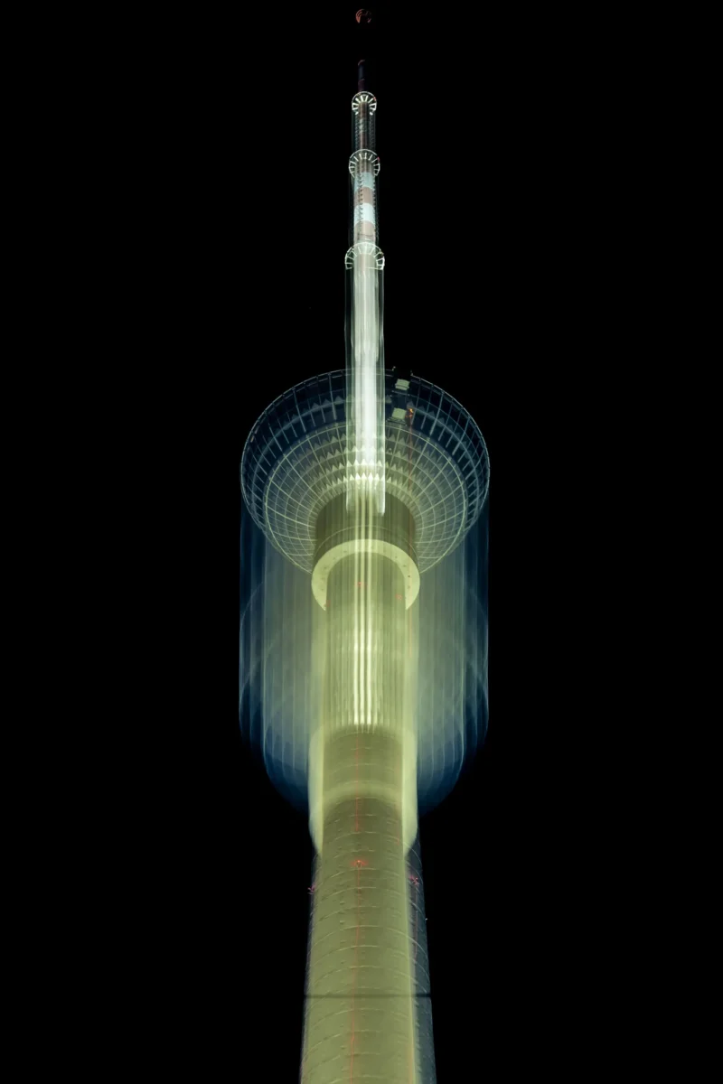 Jean-Marc · 02/05/2026 · 2599 x 3899 Cette photographie met en scène une tour lumineuse, probablement un phare ou une tour de communication, comme la tour de Tokyo.Le cadrage est serré, centré sur la structure verticale, avec un fond noir qui accentue son élancement. La lumière, dynamique et floue, crée un effet de mouvement circulaire autour de la tour, évoquant une rotation ou un balayage lumineux. Les couleurs dominantes sont des teintes vertes et jaunes lumineuses, contrastant avec le noir profond de l’arrière-plan.L’ambiance est futuriste et mystérieuse, mêlant technologie et élégance. Le style est épuré et artistique, mettant en valeur la lumière et la forme architecturale.
