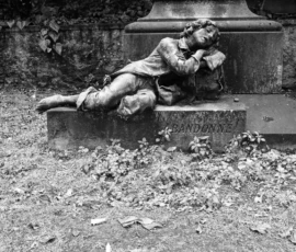 Pierre · 14/05/2026 · 5472 x 3080 Cette photographie en noir et blanc montre une statue comme sujet principal, représentant un personnage assis, penché en avant, dans une posture mélancolique. La composition est simple, centrée sur la statue posée sur un socle rectangulaire, entourée de feuilles mortes.Le cadrage est serré, mettant l'accent sur les détails de la sculpture. La lumière, douce et naturelle, crée des contrastes subtils. Les couleurs dominantes, bien que monochromes, jouent sur les nuances de gris et de noir.Le style est réaliste et sobre, évoquant une ambiance nostalgique et contemplative, renforcée par l’aspect vieilli et le décor naturel environnant.