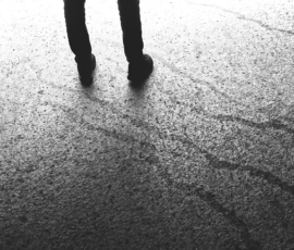 Pierre · 14/05/2026 · 4455 x 2507 Cette photographie met en scène des **pieds en mouvement** sur une surface asphaltée, capturés en contre-plongée. Le **sujet principal** est anonyme, suggérant une marche solitaire.La **composition** est épurée, centrée sur les pieds et leur ombre allongée. Le **cadrage serré** et la perspective accentuent le dynamisme et l’isolement.La **lumière**, contrastée, crée des ombres marquées, renforçant l’ambiance dramatique. Les **couleurs dominantes** sont les nuances de gris, typiques d’un cliché en noir et blanc.Le **style** est minimaliste et documentaire, évoquant une **ambiance contemplative et mélancolique**.