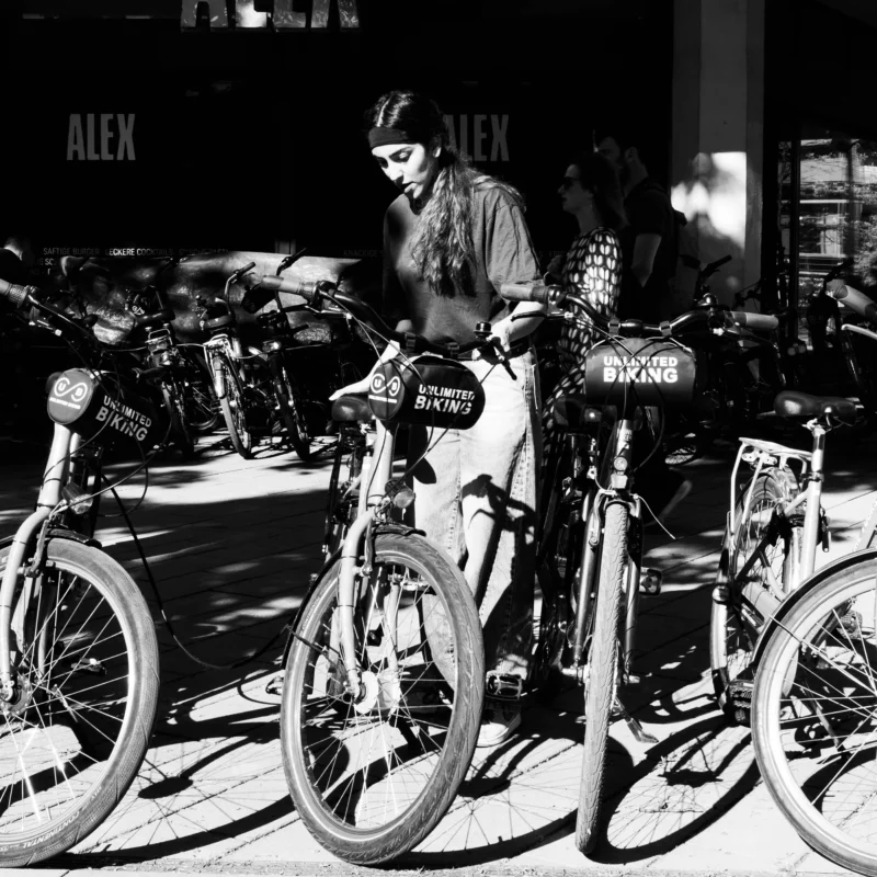 Alice · 01/05/2026 · 2801 x 2801 Cette photographie en noir et blanc met en scène un homme comme sujet principal, assis sur un vélo parmi d'autres. La composition montre une rangée de vélos alignés devant un bâtiment, avec une profondeur de champ qui isole partiellement le sujet.Le cadrage est serré, centré sur les vélos et l’homme. La lumière est douce, créant des contrastes modérés et des ombres nettes. Les couleurs dominantes sont les nuances de gris, typiques du noir et blanc, renforçant une ambiance rétro et intemporelle.Le style est documentaire et urbain, évoquant une scène de vie quotidienne. L’ambiance est calme et légèrement mélancolique.