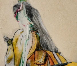 Nathalie F. · 09/05/2026 · 4160 x 4160 Cette photographie montre une fresque murale représentant une figure féminine stylisée. Le sujet principal est une femme aux traits élancés, vêtue d’une robe aux teintes vives et d’un chapeau orné.La composition est serrée, centrée sur le haut du corps. Le cadrage est rapproché, mettant en valeur les détails du visage et des vêtements. La lumière semble naturelle, éclairant les contours sans ombre marquée.Les couleurs dominantes sont des tons chauds (jaune, orange) contrastant avec des touches de vert et de gris. Le style est épuré et graphique, évoquant une ambiance à la fois artistique et légèrement mystique.