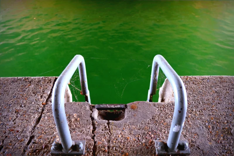 Denis · 13/09/2025 · 4898 x 3265 Cette photographie met en scène des **barreaux métalliques d’un escalier plongeant** dans une eau verte. Le **sujet principal** est la perspective plongeante, créant une impression de profondeur.La **composition** est symétrique, avec un **cadrage serré** centré sur les barreaux. La **lumière** semble naturelle, douce et légèrement tamisée, soulignant les reflets sur l’eau. Les **couleurs dominantes** sont le **vert émeraude** de l’eau et le **gris métallique** des barreaux, avec des touches de béton clair.Le style est **minimaliste et épuré**, évoquant une **ambiance calme et mystérieuse**, presque onirique.