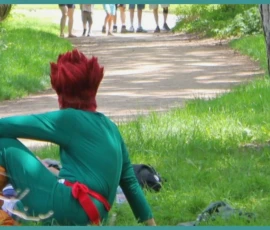 Sophie · 968 x 560 Cette photographie montre un enfant assis par terre, vêtu d’un déguisement vert et rouge évoquant un personnage de super-héros, avec une perruque rouge. Le sujet principal est flou, suggérant un mouvement ou une action.La composition est dynamique, avec un cadrage serré sur l’enfant et un arrière-plan flou de chemin et d’arbre. Les couleurs dominantes sont le vert (vêtement), le rouge (perruque) et les tons naturels du parc. La lumière semble naturelle, avec des contrastes doux.L’ambiance est ludique et spontanée, évoquant un moment de jeu ou d’aventure en extérieur.