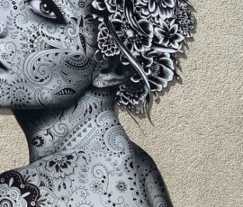 Kerry · 09/05/2026 · 3024 x 3907 Cette photographie montre un **mural en noir et blanc** représentant une femme stylisée. Le **sujet principal** est son visage et ses cheveux ornés de motifs floraux et géométriques complexes.La **composition** est serrée, avec un **cadrage rapproché** mettant en valeur les détails. La **lumière** semble naturelle, éclairant le mur de façon uniforme. Les **couleurs dominantes** sont le noir et le blanc, renforçant le contraste et les textures.Le **style** est artistique et graphique, évoquant l’art urbain ou le street art. L’**ambiance** est à la fois élégante et mystérieuse, grâce aux motifs intricats et à la précision des traits.