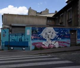 Muriel · 09/05/2026 · 2048 x 1365 Cette photographie montre un camion dont la caisse est transformée en support artistique. Le **sujet principal** est le **mural coloré** représentant une femme stylisée aux traits délicats, entourée de motifs célestes.La **composition** est équilibrée, avec le camion centré sur la chaussée. Le **cadrage** est serré, mettant en valeur les détails du graffiti. La **lumière** est naturelle, avec des ombres douces, suggérant un jour ensoleillé. Les **couleurs dominantes** sont bleues, roses et blanches, créant un contraste vibrant.Le **style** est artistique et urbain, évoquant une ambiance **créative et dynamique**, typique de la street art. L'atmosphère est à la fois moderne et poétique.