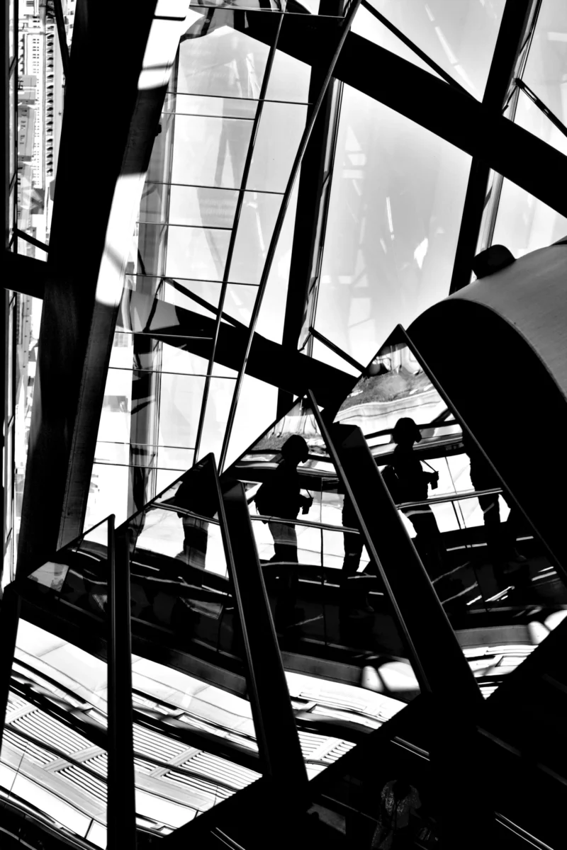 Fabienne · 01/05/2026 · 3231 x 4847 Cette photographie met en scène une structure métallique complexe, probablement une partie d’un phare ou d’une tour. Le sujet principal est l’architecture géométrique des poutres et des vitres, formant des motifs angulaires.Le cadrage est serré, accentuant les lignes et les jeux d’ombres. La lumière, naturelle et contrastée, crée des reflets et des ombres marquées, renforçant le côté dramatique. En noir et blanc, les tons dominants varient du blanc pur aux noirs profonds, avec des gris intermédiaires.Le style est épuré et minimaliste, évoquant une ambiance industrielle et mystérieuse, presque abstraite.