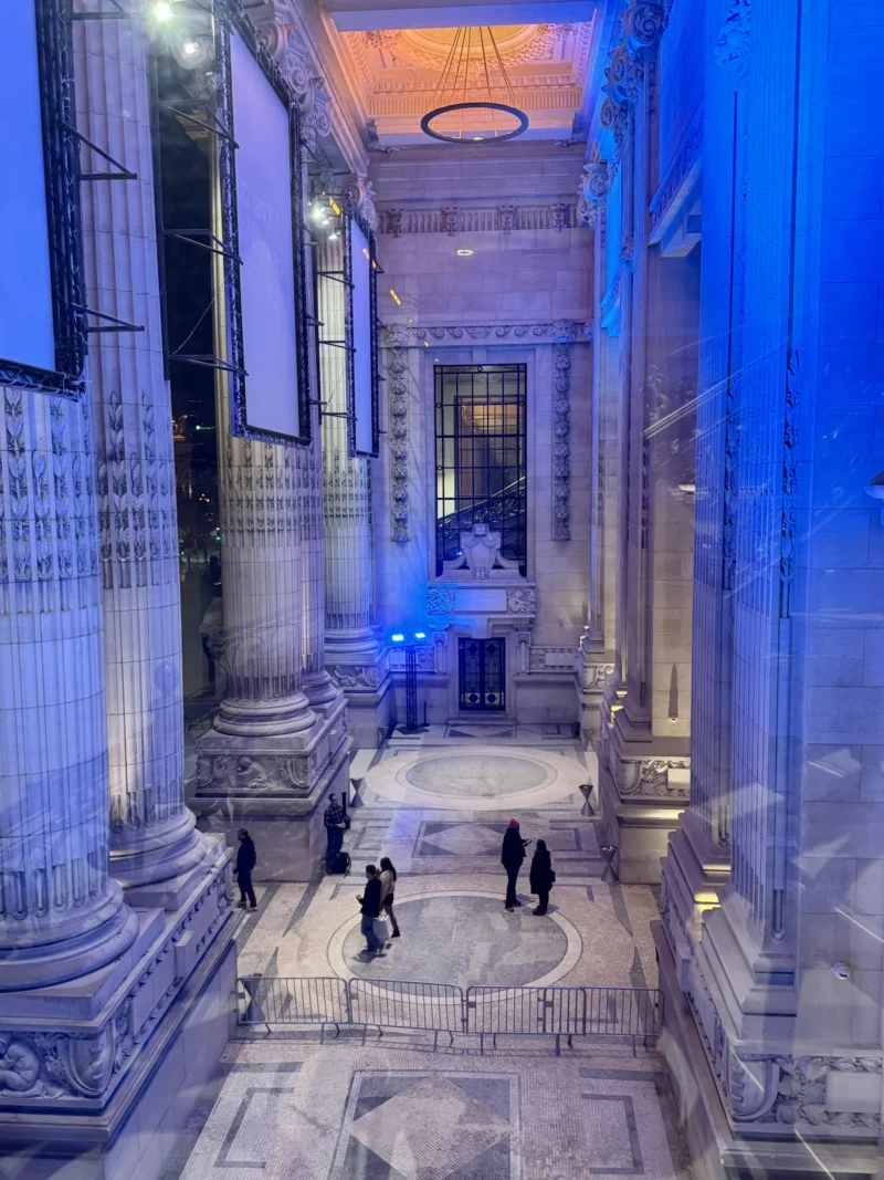 Heike · 19/12/2025 · 4284 x 5712 Cette photographie montre un intérieur architectural imposant, probablement un lieu historique ou religieux. Le sujet principal est l’espace central avec ses colonnes majestueuses et son escalier.La composition est symétrique, avec une perspective axiale menant vers le fond. Le cadrage est large, capturant une vue plongeante depuis une hauteur.Les couleurs dominantes sont des tons froids (bleus, gris) avec des éclairages artificiels bleutés, créant une ambiance mystérieuse et solennelle. Le style est classique, renforcé par les détails architecturaux. L’ambiance est à la fois majestueuse et légèrement dramatique.