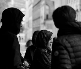 Thomas · 14/05/2026 · 2850 x 3800 Cette photographie en noir et blanc met en scène trois personnes dont une enfant au centre, entourée de deux adultes. Le sujet principal est cette enfant, entourée et soutenue par les adultes.La composition est serrée, avec un cadrage rapproché qui isole le groupe du reste de la scène. La lumière est douce mais contrastée, créant des ombres marquées. Les couleurs dominantes sont les nuances de gris, typiques du noir et blanc.Le style est documentaire et intime, évoquant une ambiance chaleureuse et protectrice, presque mélancolique.