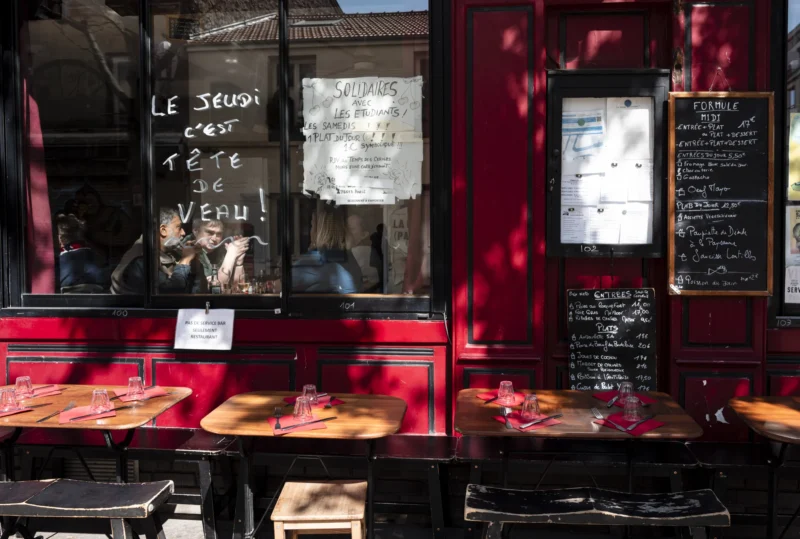 Jean-Philippe · 14/04/2026 · 8515 x 5742 Cette photographie montre l’intérieur d’une pizzerie ou d’un restaurant. Le sujet principal est une vitrine avec des pizzas exposées derrière une paroi rouge.La composition met en valeur les plats et les éléments décoratifs comme les menus et les inscriptions murales. Le cadrage est serré, centré sur la vitrine et légèrement incliné.La lumière est naturelle et tamisée, créant une ambiance chaleureuse. Les couleurs dominantes sont le rouge vif de la paroi et les tons chauds des aliments. Le style est réaliste et spontané, évoquant une ambiance conviviale et authentique.