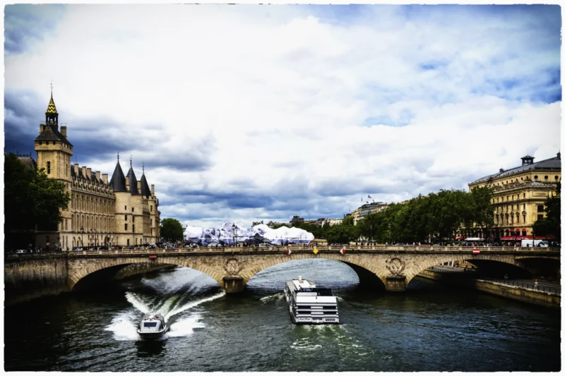 Thierry · 11/06/2026 · 3840 x 2560 Cette photographie capture un pont parisien, probablement le Pont de l'Alma, sur la Seine. Le sujet principal est un bateau à haute vitesse, créant une traînée d'eau. La composition met en valeur l'architecture classique des bâtiments en arrière-plan, dont l'Hôtel de la Marine.Le cadrage est dynamique, centré sur le mouvement du bateau. La lumière, naturelle et légèrement contrastée, donne une ambiance claire malgré des nuages. Les couleurs dominantes sont les tons bleus et gris de l'eau et du ciel, avec des touches de beige et de vert. Le style est photographique réaliste, avec une touche de flou artistique pour accentuer le mouvement. L'ambiance est à la fois urbaine et vivante.