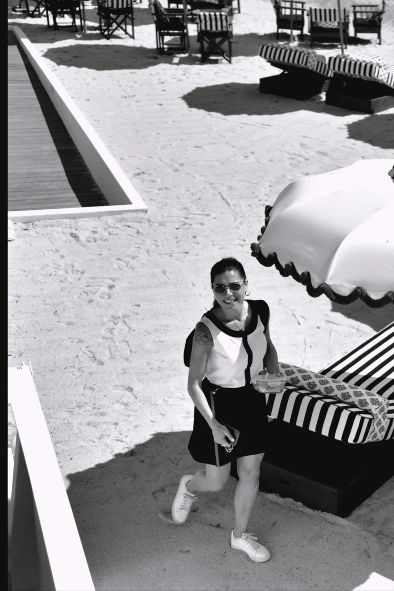 Fabienne · 4124 x 6186 Cette photographie en noir et blanc met en scène un enfant comme sujet principal, vêtu d’un short et d’un haut de bain, marchant près d’un parasol à rayures. La composition est simple, avec un cadrage serré sur le sujet et un arrière-plan minimaliste : une allée et des tables de piscine.La lumière semble naturelle, probablement en extérieur, créant des contrastes marqués. Les couleurs dominantes sont les nuances de gris, typiques du noir et blanc, accentuant les textures et ombres.Le style est documentaire et spontané, évoquant une ambiance détendue et nostalgique, typique d’un moment de loisir estival.