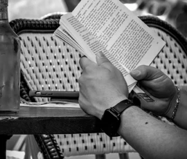 AnJo · 30/05/2026 · 1280 x 1920 Cette photographie en noir et blanc met en scène une personne lisant un livre, sujet principal. La composition est simple et centrée sur les mains tenant le livre ouvert. Le cadrage est serré, isolant partiellement le visage et mettant l'accent sur l'action de lecture.La lumière semble naturelle, douce et légèrement tamisée, créant des contrastes subtils. Les couleurs dominantes sont les nuances de gris, typiques d'une photo en noir et blanc.Le style est documentaire et intime, évoquant une ambiance calme et contemplative, presque nostalgique.