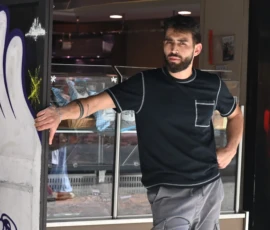 Pierre · 30/05/2026 · 3255 x 2166 Cette photographie met en scène un homme comme sujet principal, vêtu d’un t-shirt noir et d’un pantalon gris, posant devant une vitrine urbaine. La composition est simple et centrée, avec un cadrage serré sur lui.La lumière semble naturelle, légèrement tamisée, créant des contrastes doux. Les couleurs dominantes sont les tons sombres (noir, gris) avec des touches de couleurs vives sur les graffitis en arrière-plan.Le style est réaliste et spontané, évoquant une ambiance urbaine et décontractée, presque artistique grâce aux éléments street art.
